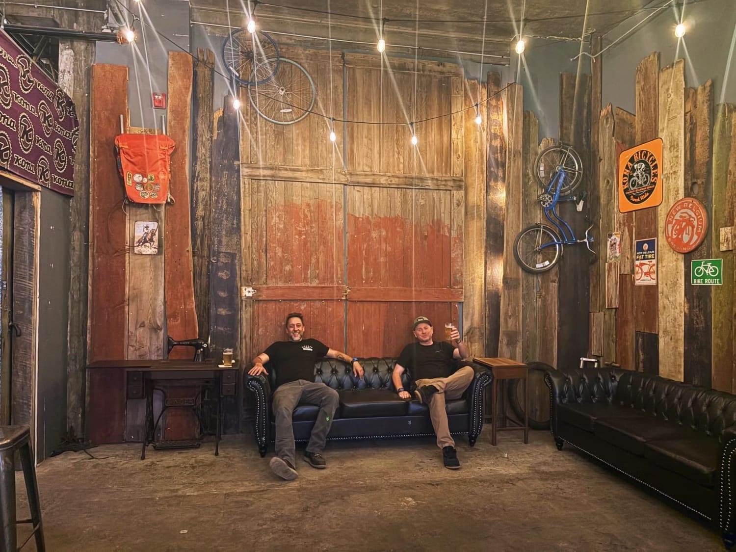 Two of the society sitting on a couch in a barn after a ride