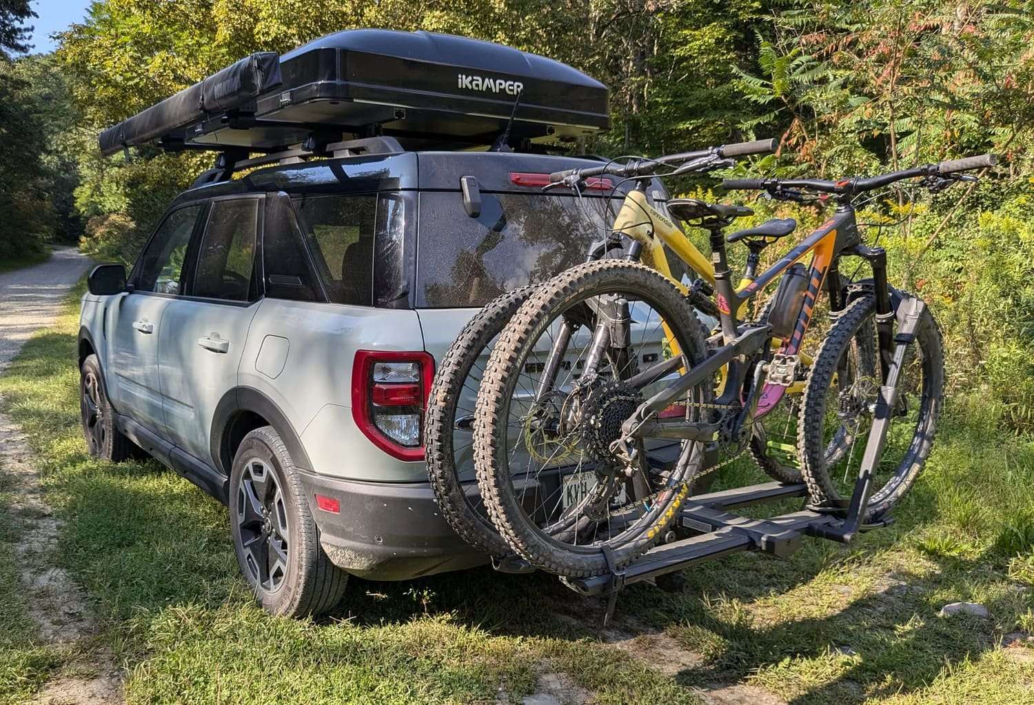Bikes loaded on a hitch rack at a gravel trailhead